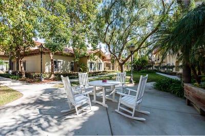 Outdoor seating area with rocking chairs and a garden
