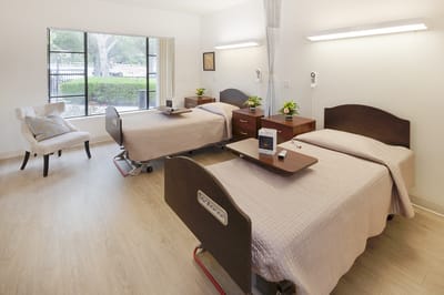 A comfortable resident room with two beds and seating