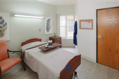 Private resident room with a bed and chair