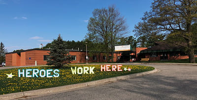 Exterior view of a nursing home with a welcoming sign