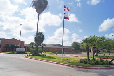 Exterior view of Mission Nursing and Rehabilitation Center with flags