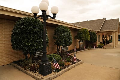 Well-maintained outdoor space with decorative shrubs and flags