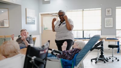 Residents participating in an engaging activity with a staff member