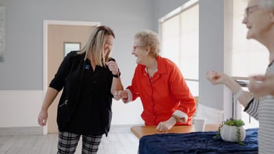 Residents and staff laughing together in a common area
