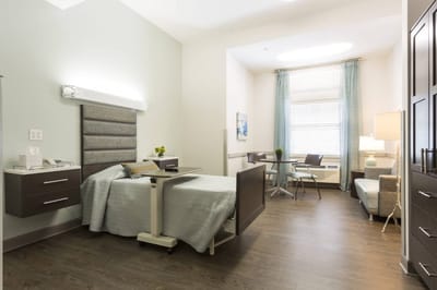 Bright interior of a private resident room with a bed and seating area