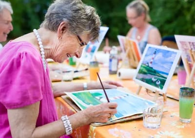 Residents enjoying an outdoor painting activity.