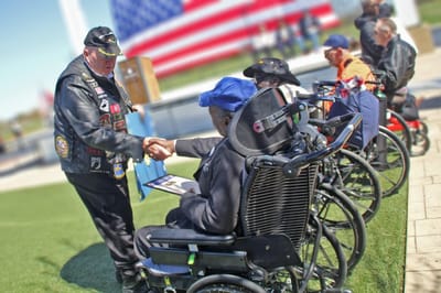 Veterans at an outdoor event shaking hands