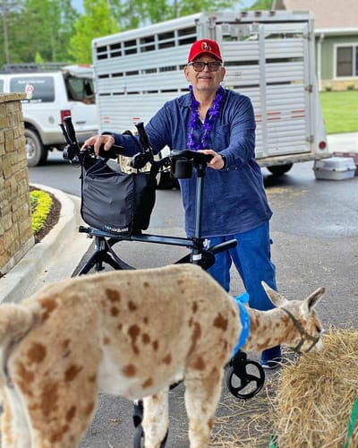 Resident interacting with a llama outside.