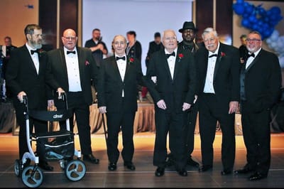 Elderly men in tuxedos at a special event.