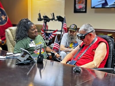 Staff interacting with a resident in a meeting room.