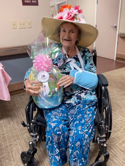 Resident in a wheelchair holding a gift basket