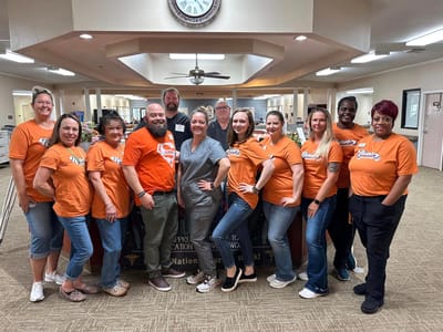 Staff and residents in casual shirts at facility