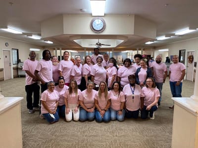 Staff members posing together in pink shirts