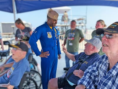 Veterans engaging outdoors with military personnel.