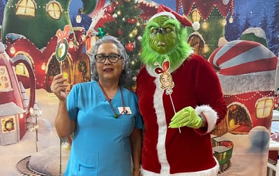 Staff member with a character costume at a festive event.