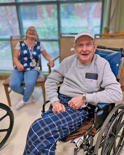 Resident enjoying time with staff in the common area.