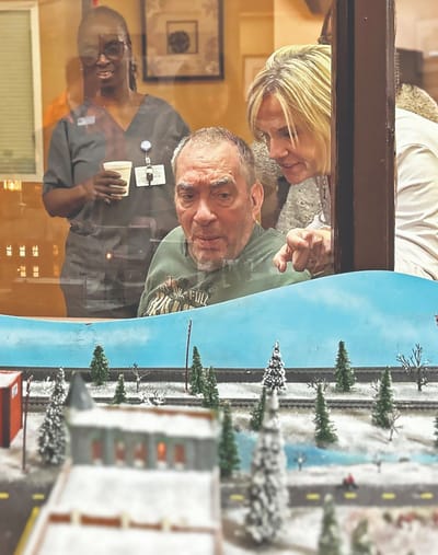 A resident interacting with staff by a display window.