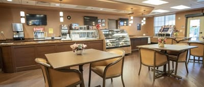 Cozy dining area with tables and dessert display.