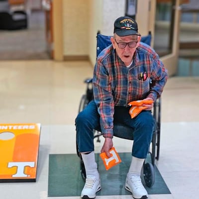 Elderly man in wheelchair with orange items