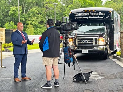 Interview with facility representative in front of transport bus.