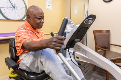 Senior man using a stationary exercise machine.