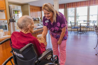 Staff member assisting a resident in a common area.