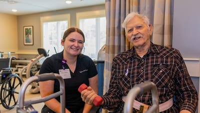 Resident and staff member engaging in light exercise