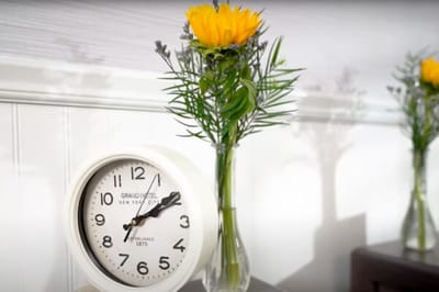 Clock and flower vase on a table