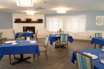 Dining area with blue tables and flowers.