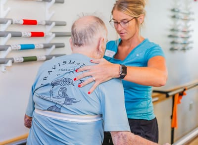 Caregiver assisting an elderly resident during therapy
