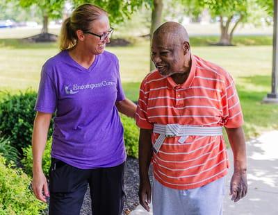 Staff member assisting a resident outdoors.