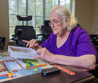 Senior woman working on a puzzle indoors.