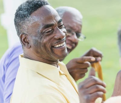 Two smiling men engaging in a joyful conversation.