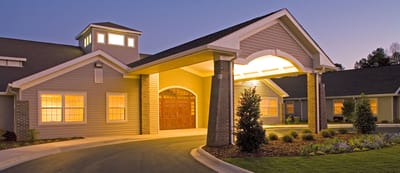Exterior view of assisted living facility entrance at dusk