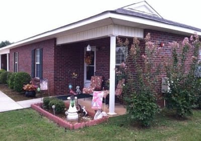 Exterior view of assisted living facility with garden.
