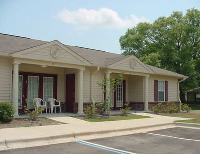 Exterior view of assisted living facility with chairs