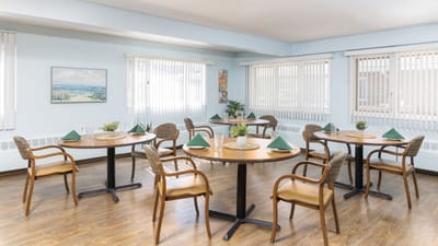 Dining area with tables set and green napkins