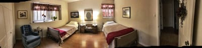 A shared room with two beds and window seating.
