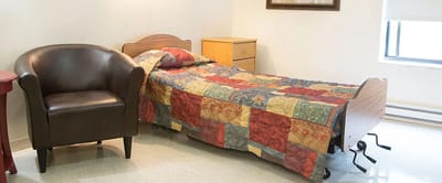 A private room with a bed and chair