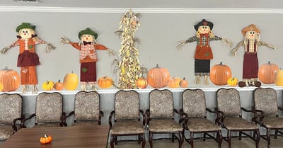 Decorative scarecrows on a wall in a common area