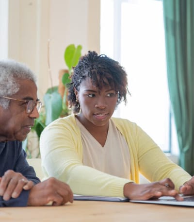 Two residents discussing at a table in a bright room