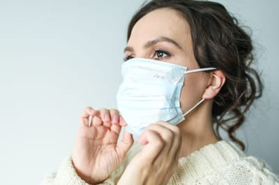 Woman putting on a face mask indoors