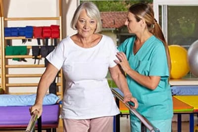 Therapist assisting senior with mobility