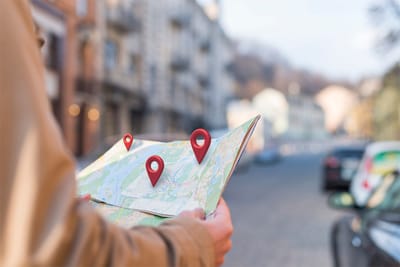 A person holding a map with location markers