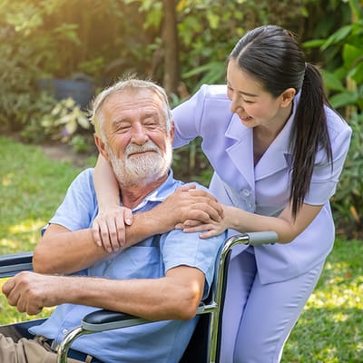 Care staff assisting a resident in the garden