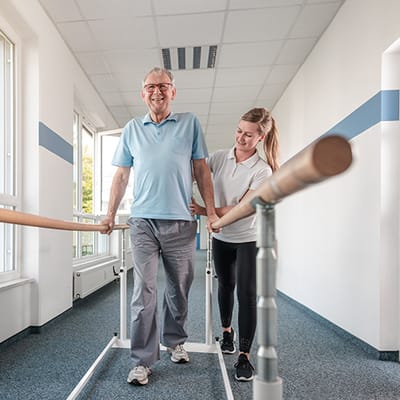 A senior man receiving assistance in a therapy space