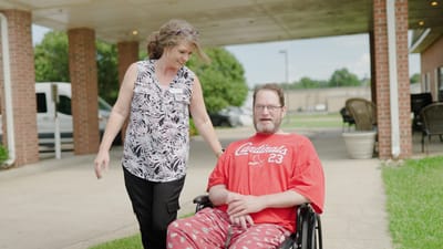 Staff member assisting a resident outdoors.
