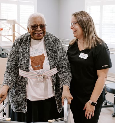 Senior resident with staff member in activity space