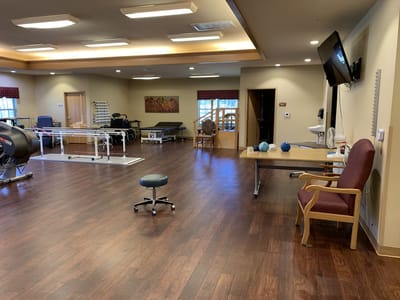 Physical therapy gym with equipment and seating