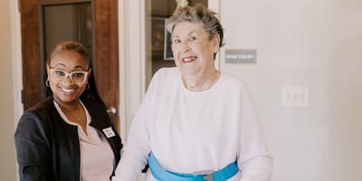 A staff member assisting a resident in a therapy area